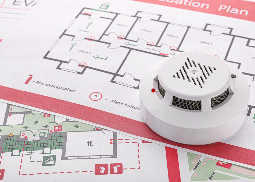 An egress map showing evacuation routes and fire protection unit locations held down by a detector.  